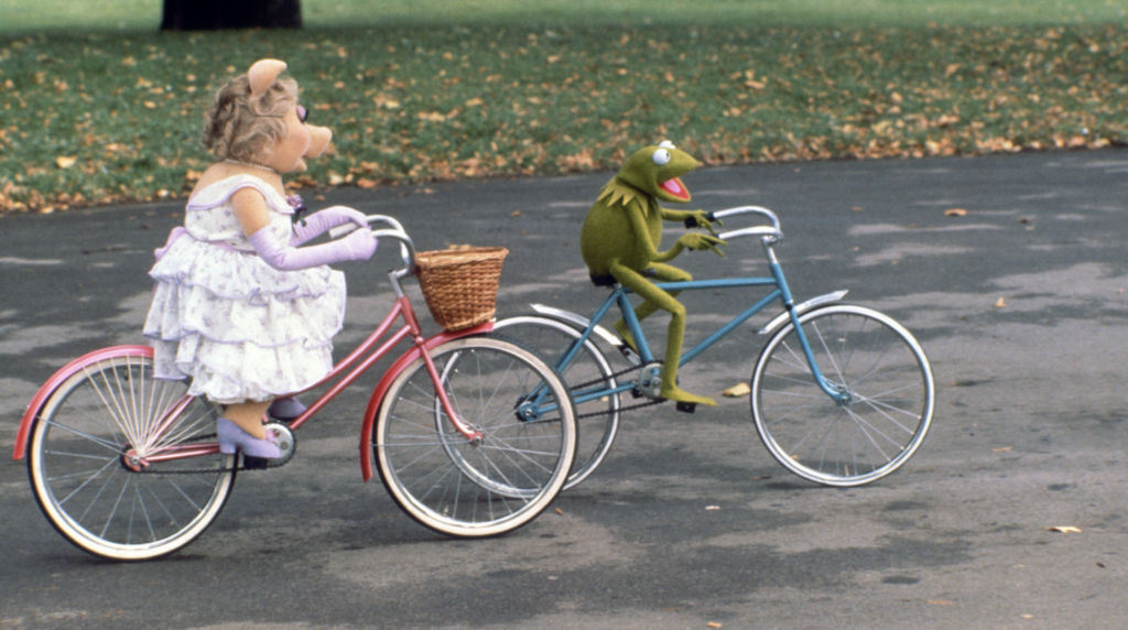 Kermit the Frog and Miss Piggy riding bikes, The Great Muppet Caper, 1981